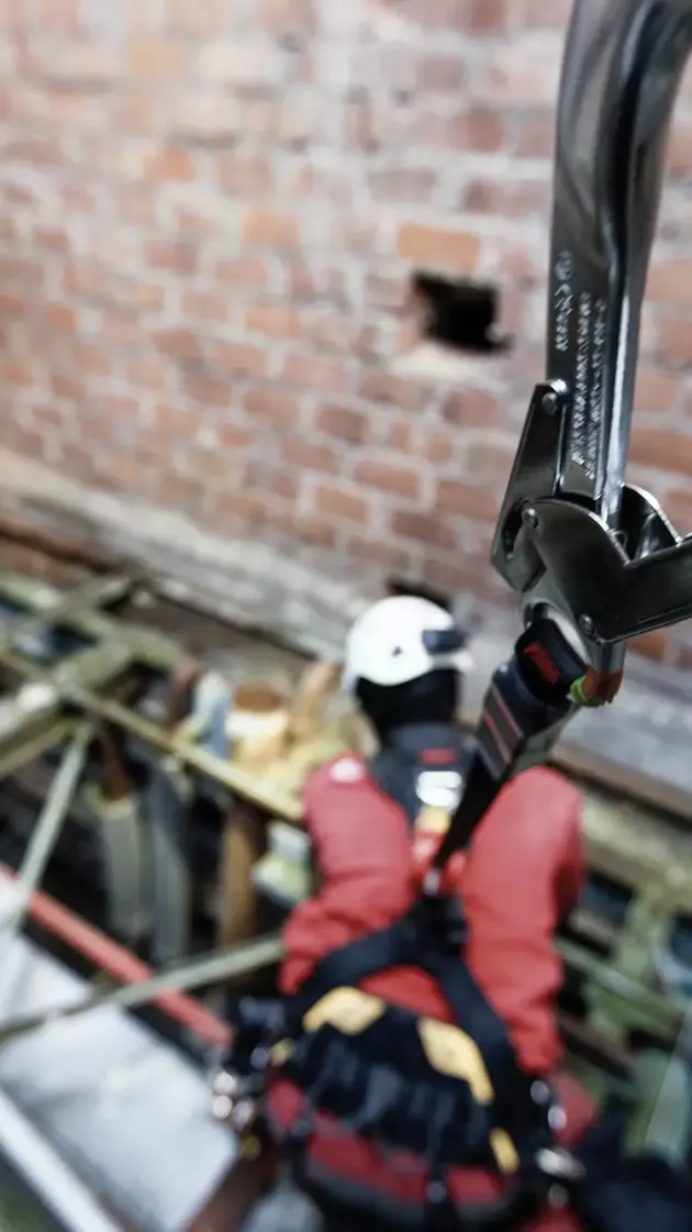 Travailleur en hauteur en formation équipé d’un harnais relié par un enrouleur automatique. 